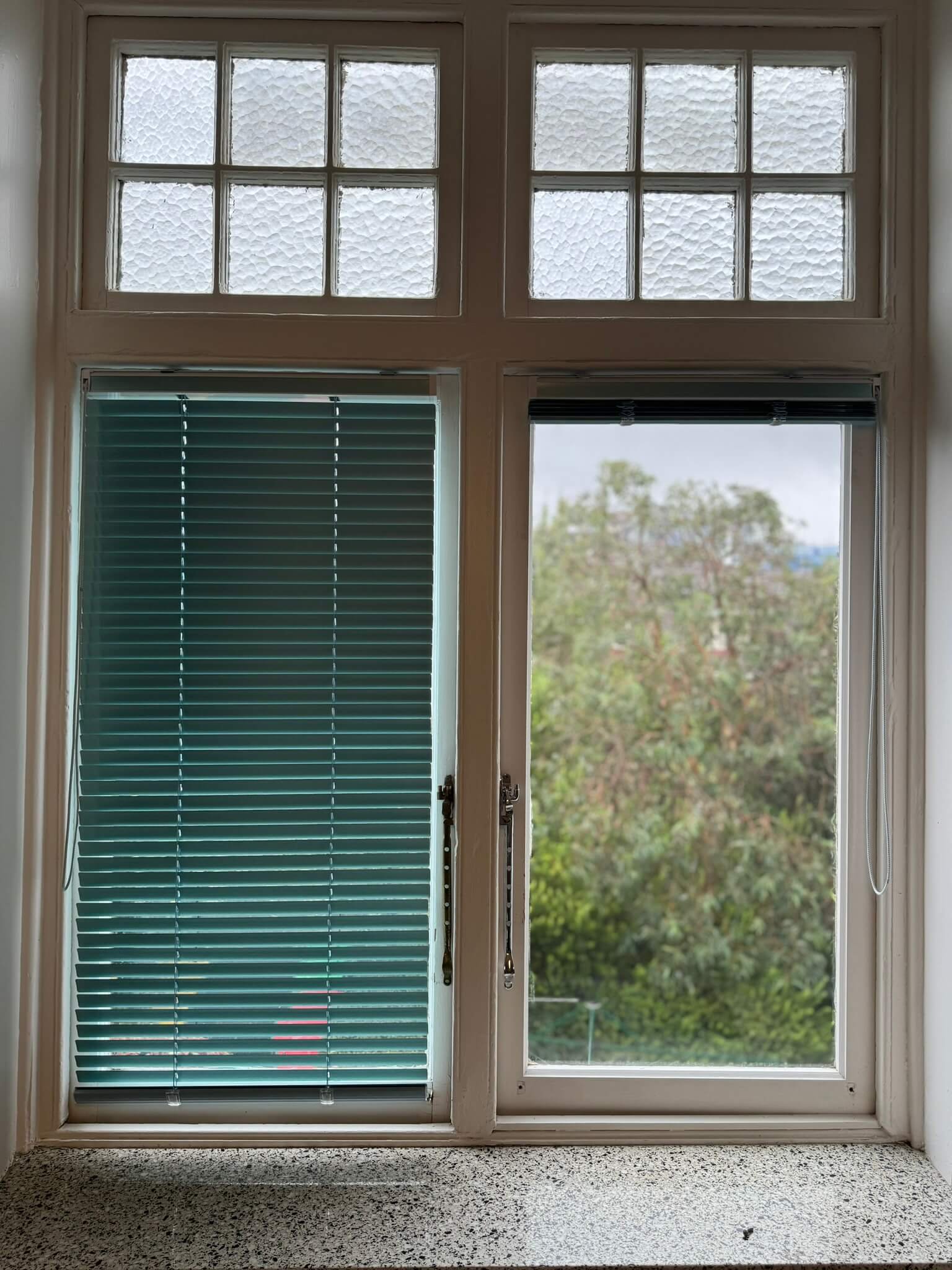 Custom-made Venetian blinds installed in a modern kitchen for light control.